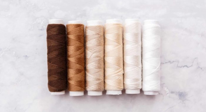 colorful sewing and tailoring tools and items on light background