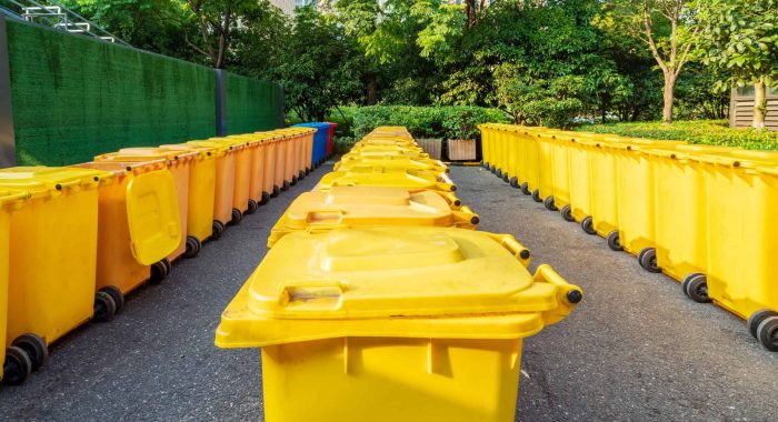 overfilled trash of large wheelie bins for rubbish, recycling and garden waste