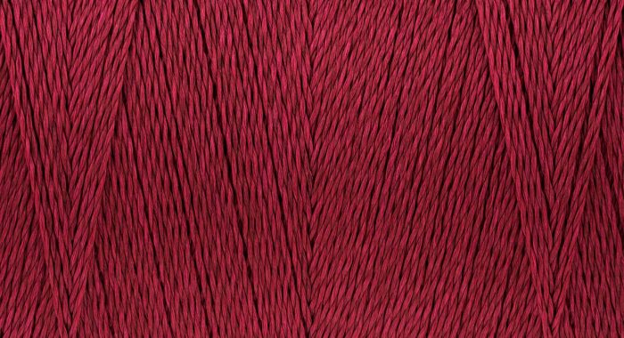 Macro picture of sew thread texture dark crimson color surface background