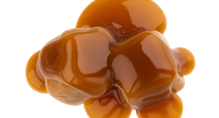 Toffee candies and caramel sauce isolated on white background with clipping path, top view
