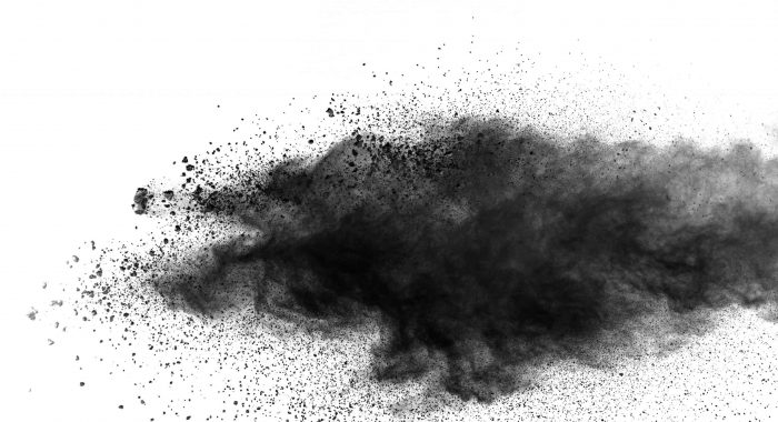 Black particles splatter on white background. Black powder dust burst.