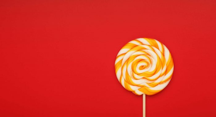 Colorful round Lollipop, on pink, mint blue, red background. Minimal concept with copy space. Confectionery, sweets