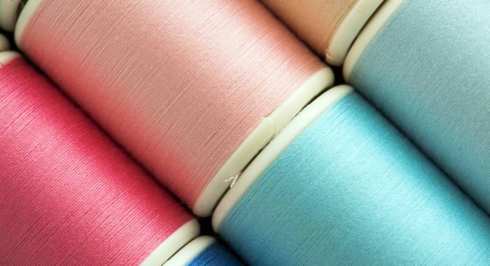 Colorful sewing threads background closeup