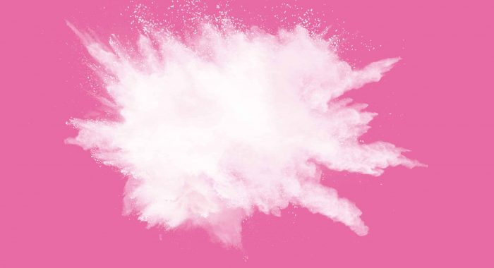 Abstract white powder explosion on pink background. Freeze motion of white dust splattered.