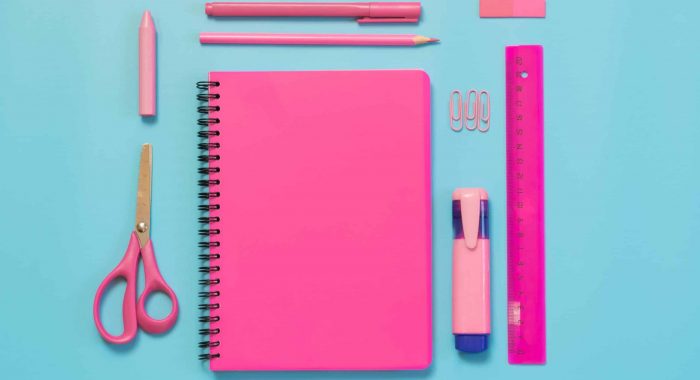 Pink girlish school supplies, notebooks and pens on punchy blue background. Top view, flat lay. Copy space. Back to school.