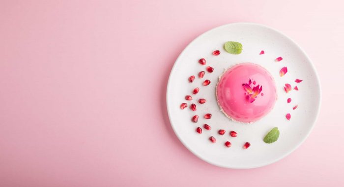 Pink mousse cake with strawberry on a pastel pink background. top view, flat lay, copy space.