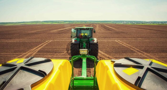 Tractor plowing farm field in preparation for spring planting.