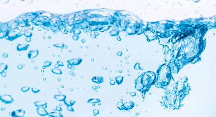 Surface of the blue water waves splash on a white background